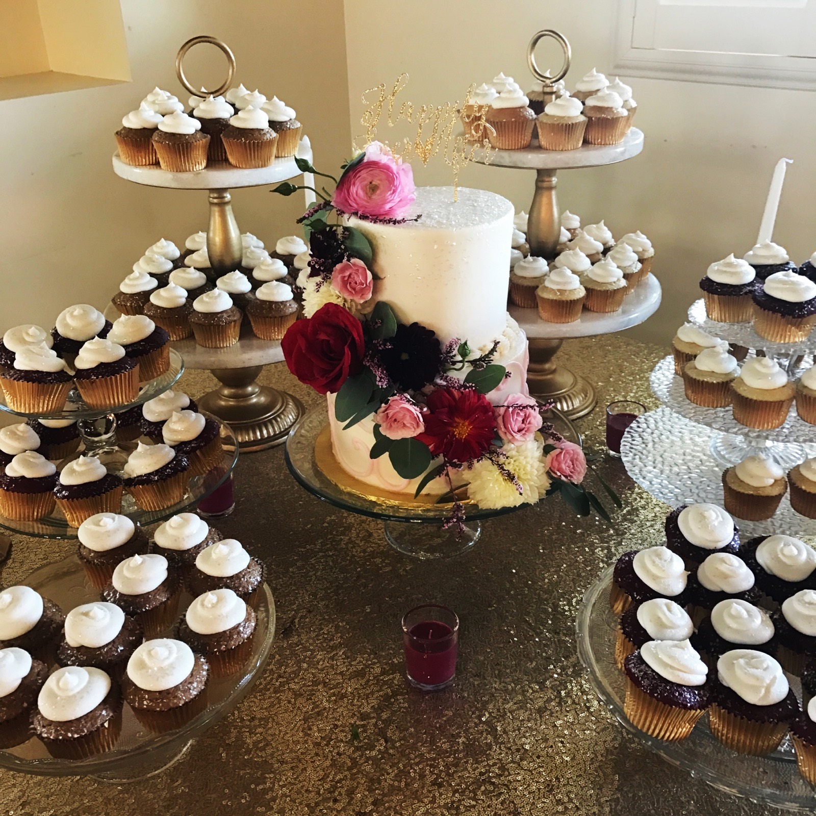 Cake-and-cupcake display with fresh flowers