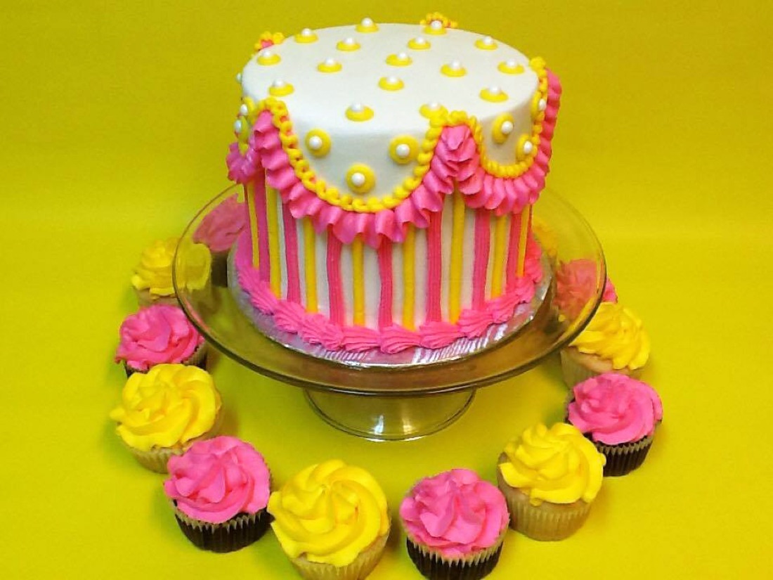 Pink and yellow cake with matching cupcakes
