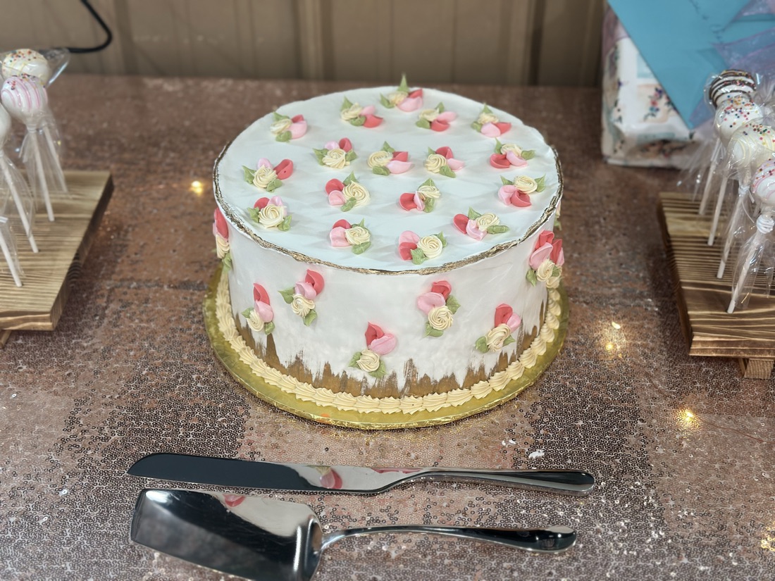 Round cake covered in piped rosebuds with cake pops