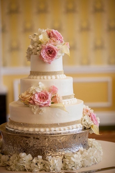 White tiered wedding cake finished with soft pink roses