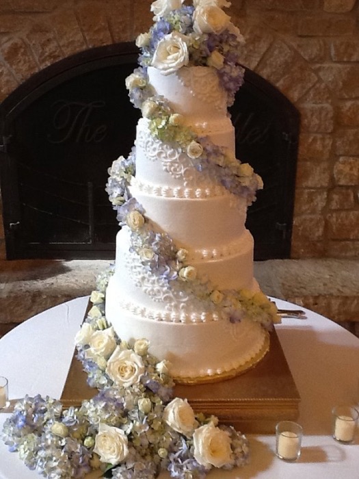 White wedding cake with a cascade of lavender florals