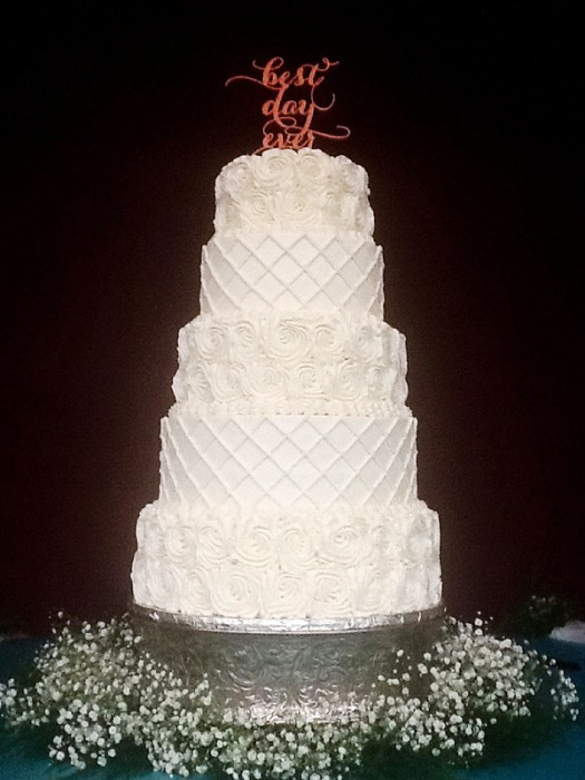 White quilted wedding cake with baby's breath and a best-day topper