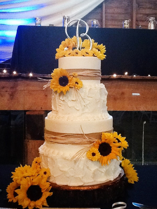 Rustic white wedding cake finished with sunflowers and twine